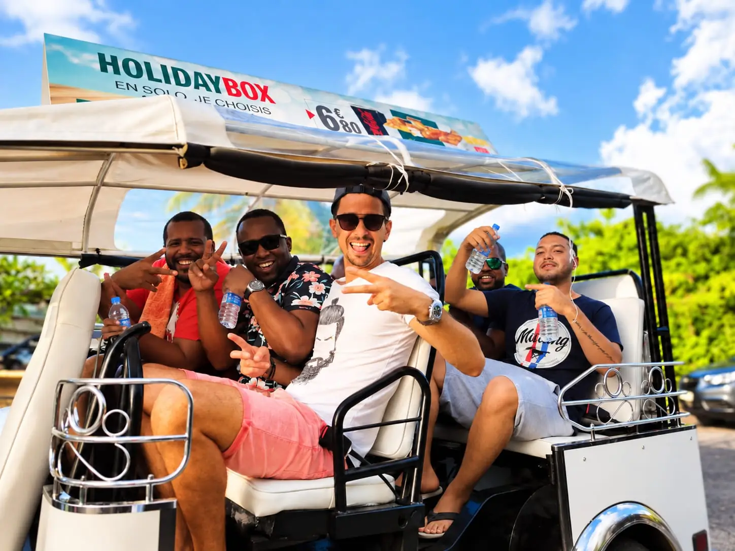 Passengers on board a Pousse Pousse electric golf cart, ready to tour Pointe-à-Pitre