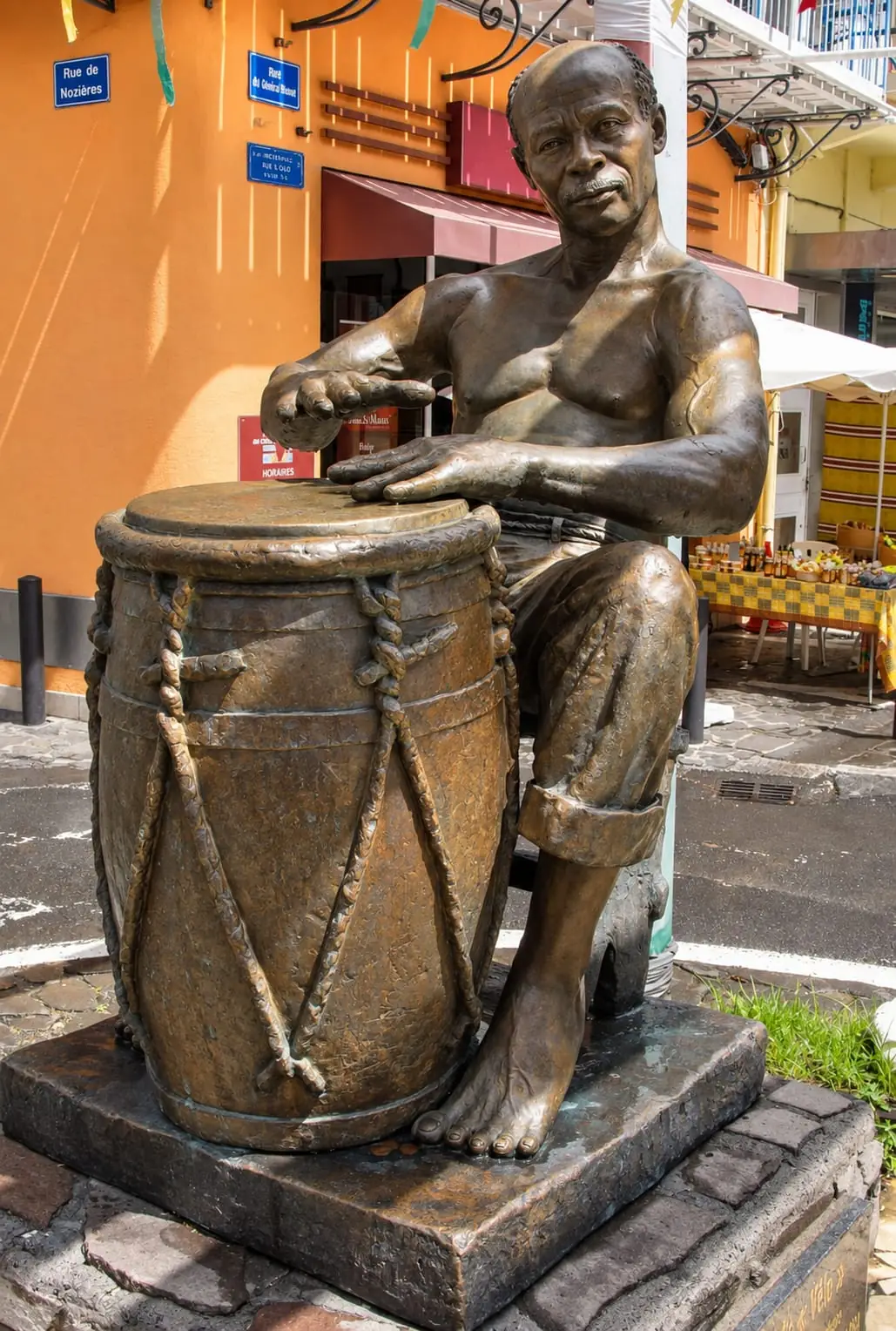 Bronze sculpture of a ka drum player